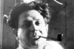Schwarz-Weiß Portrait von Kurt Tucholsky. Er hat eine Pfeife im Mundwinkel.